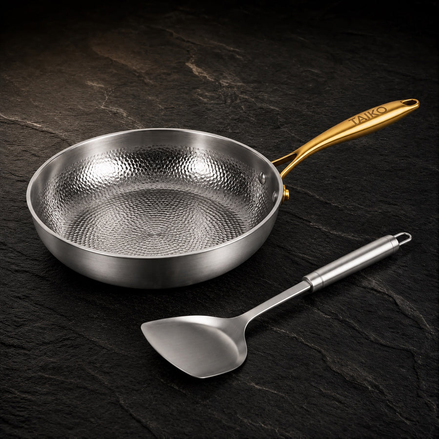 Pure Safe Titanium Hammered Pan with Utensil on a dark slate background