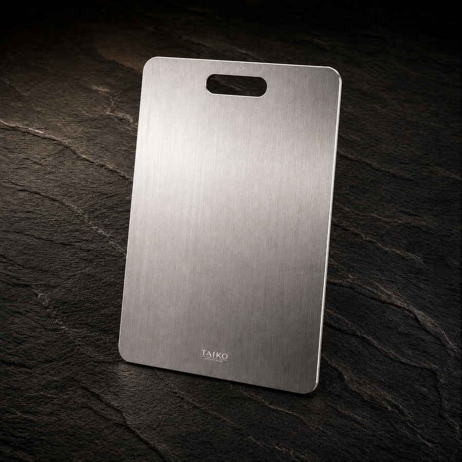 Pure Safe Titanium Cutting Board on a dark slate background